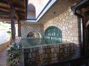 an indoor pool in a stone building with a stone wall at Eco-selo Grabovica in Grabovica
