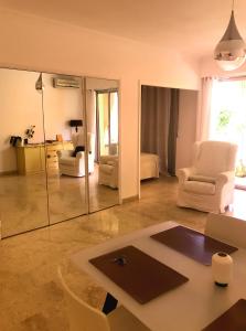 ein Wohnzimmer mit einem Tisch, Stühlen und einem Spiegel in der Unterkunft Monaco Studio "907" in Monte Carlo