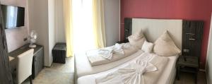 Un dormitorio con una cama blanca con almohadas. en Hotel Sophia, en Warendorf