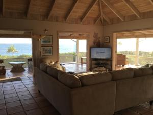 a living room with a couch and a television at Coconut Beach House in Green Turtle Cay
