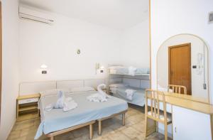 a hospital room with two beds and a mirror at Albergo Villa Denny in Rimini