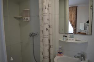 a bathroom with a shower curtain with writing on it at Globe Hotel in Colchester
