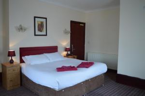 a hotel room with a bed and a dresser at Globe Hotel in Colchester