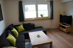 sala de estar con sofá, mesa y TV en gemütliche Ferienwohnung in der Lüneburger Heide, en Schneverdingen