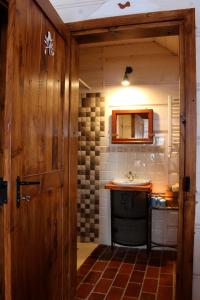 a bathroom with a sink and a wooden door at Buczynowe Chaty in Wysowa-Zdrój