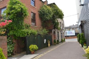 a brick building with a black gate and a street at Globe Hotel in Colchester