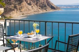 a table with drinks and a bowl of fruit on a balcony at Palazzo Greco in Agia Galini