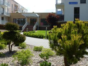 a garden in front of a building with trees at Silver Bursztynowe Komnaty in Darlowko