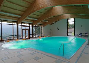ein großer Pool in einem Gebäude mit Fenstern in der Unterkunft Osserhotel Garni in Lohberg