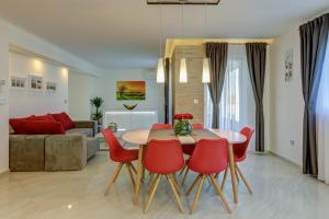a living room with a table and red chairs at Viras Luxury Holiday in Premantura