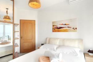 ネア・カリクラティアにあるVillas Angaraのベッドルーム1室(ベッド1台付)が備わります。壁には絵画が飾られています。