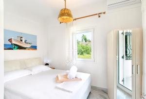 ネア・カリクラティアにあるVillas Angaraの白いベッドルーム(ベッド1台、窓付)