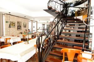 a staircase in a restaurant with tables and chairs at Galatas Central Hotel in Patos de Minas