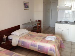 a bedroom with a bed and a small kitchen at Gikas Apartments Triple Studio Sea View B7 in Marmari