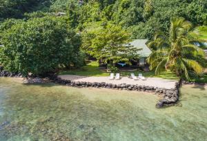 een luchtzicht op een strand met stoelen en een huis bij Robinson's Cove Villas - Deluxe Wallis Villa in Papetoai