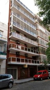 um prédio de apartamentos com dois carros estacionados em frente em F&F Altos de Barracas em Buenos Aires