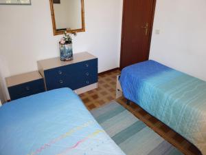 リニャーノ・サッビアドーロにあるResidence Giardinoのベッドルーム1室(ベッド2台、ドレッサー、鏡付)