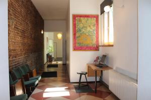 a hallway with a desk and chairs and a brick wall at Die Fabrik - Hostel in Berlin