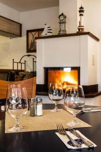 a table with wine glasses on a table with a fireplace at Hotel Admiral in Lipno nad Vltavou