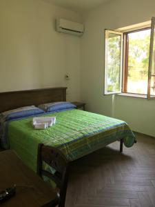 a bedroom with a green bed and a window at Luna D'Agerola in Agerola