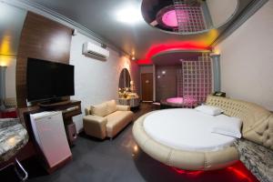 1 dormitorio con 1 cama blanca grande y TV en Shanadu Motel (Adults Only) en Fortaleza