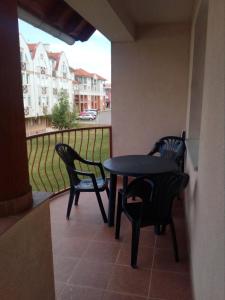 a table and chairs on a balcony with a view at GÓBÉ Apartman in Hajdúszoboszló