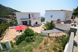 a house with a red umbrella on a hill at Lloret Apartments in Lloret de Mar
