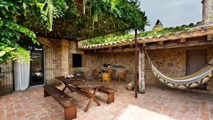 a patio with a wooden table and a hammock at Encís d'Empordà -Adults Only- in Casavells +60 photos