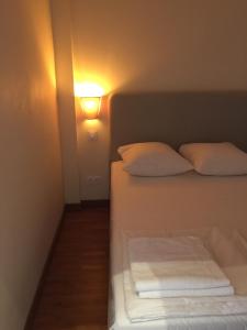 モンペリエにあるCœur de ville grand-rue Jean Moulinのベッド1台(枕2つ付)、壁にライトが備わります。
