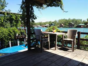 einen Tisch und Stühle auf einer Terrasse neben dem Wasser in der Unterkunft Ada Bojana Apartmani in Ulcinj