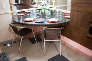 uma mesa de jantar com cadeiras e pratos em Shanadu Motel (Adults Only) em Fortaleza