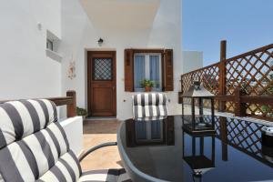 a balcony with a glass table and chairs at Aerolithos in Adamantas