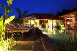 a villa with a swimming pool at night at Bali Sunshine Ubud in Ubud