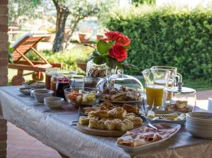 una mesa con comida y bebidas. en Il Giardino delle Rose, en Santa Maria Nuova
