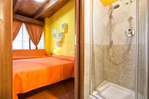 1 dormitorio con ducha, 1 cama y bañera en Affittacamere Zahra, en Alghero