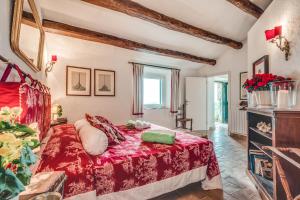 a bedroom with a bed with a red bedspread at Borgo degli Ulivi in Porto Ercole