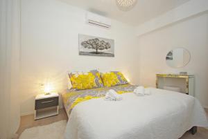 a bedroom with a white bed with yellow pillows at "NM" Luxury apartments in Split
