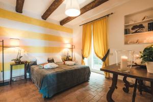 a bedroom with a bed and a table in a room at Borgo degli Ulivi in Porto Ercole