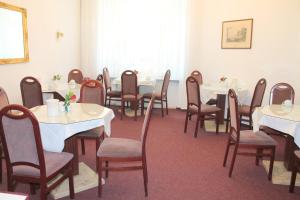 ein Esszimmer mit weißen Tischen und Stühlen in der Unterkunft Hotel Novalis in Berlin