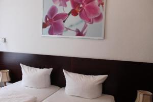 a bed with two pillows and a picture on the wall at Hotel Novalis in Berlin +30 photos