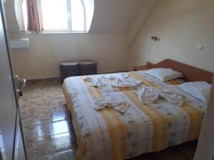 una camera da letto con un letto e asciugamani di Hotel Palace a Kranevo