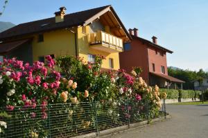 a house with a bunch of flowers in front of it at Residence Girasole Casa Gialla in Colico