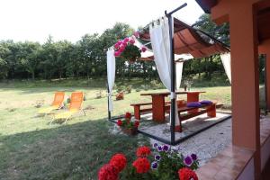 a picnic table and chairs in a yard with flowers at Apartments Matelici in Divšići