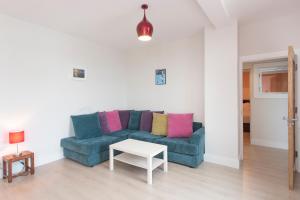 a living room with a blue couch and a table at Garryvoe Beach Homes in Garryvoe