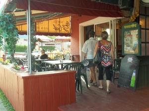 two people walking into a restaurant with tables and chairs at Auberge le St-Gab in Saint-Gabriel-de-Brandon