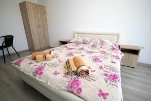a bedroom with a bed with pink flowers and towels at Apartments Victoria in Sutomore
