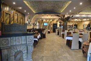 a restaurant with white tables and white chairs at Hotel Talija in Svilajnac