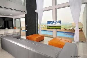 a living room with a tv and a large window at Villa Aqua Boutique in Safed