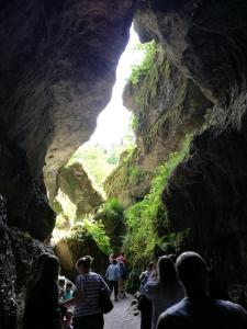 eine Gruppe von Menschen, die in einer Höhle mit einem Wasserfall stehen in der Unterkunft Longmen Mountain Villa in Egloffstein
