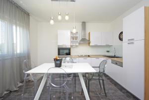 a white kitchen with a white table and chairs at "NM" Luxury apartments in Split